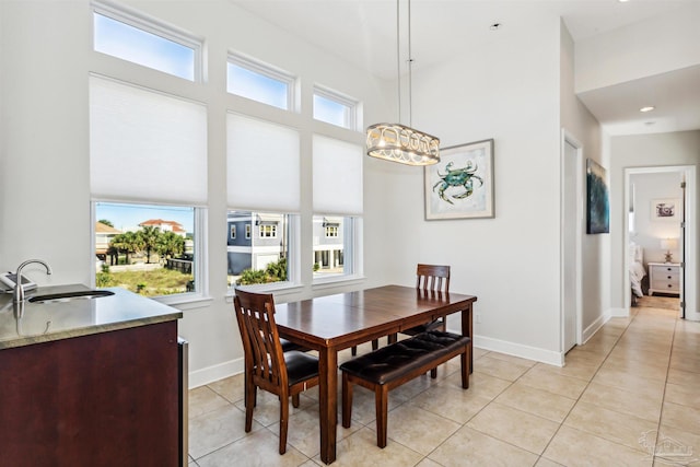 tiled dining area with a healthy amount of sunlight, sink, and a chandelier