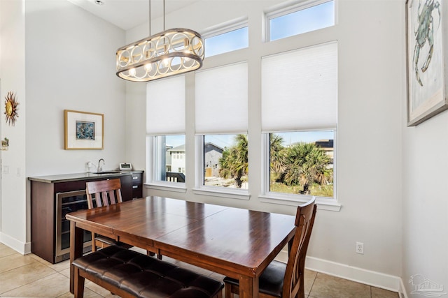 dining area featuring wine cooler, sink, and light tile patterned flooring