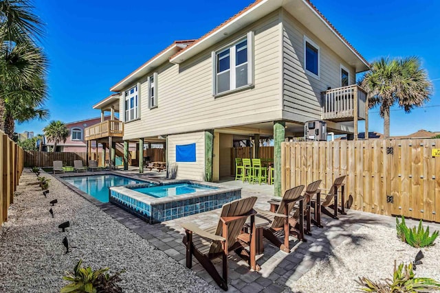 view of swimming pool featuring a patio area and an in ground hot tub