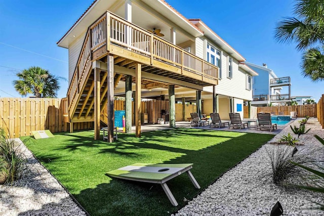 rear view of house with a patio area, a swimming pool side deck, a yard, and ceiling fan