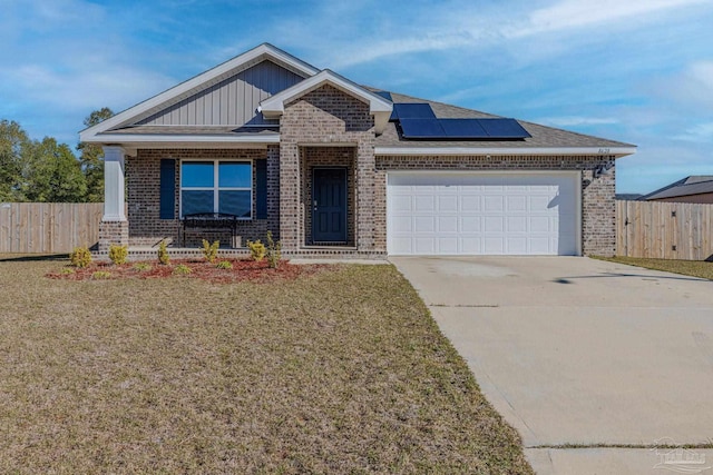 8628 Tarsus Dr, Milton, FL 32583 - view of front facade featuring solar panels, an attached garage, brick siding, and driveway