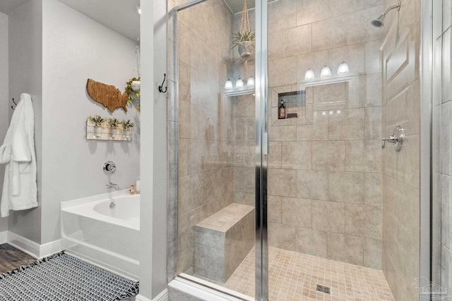 bathroom featuring plus walk in shower and hardwood / wood-style flooring