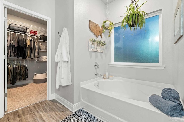 bathroom featuring wood-type flooring and a tub