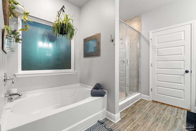 bathroom featuring hardwood / wood-style flooring and separate shower and tub