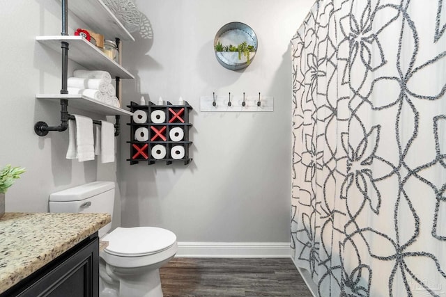 bathroom with vanity, hardwood / wood-style floors, toilet, and curtained shower