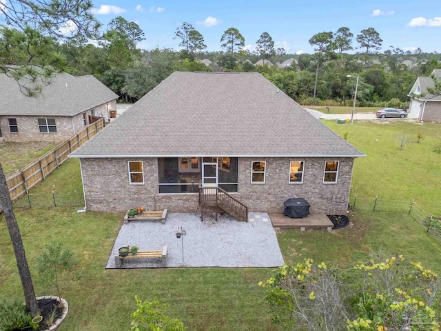 rear view of house featuring a yard and a patio