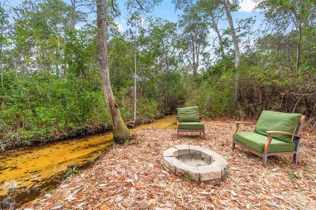 view of yard featuring a water view and a fire pit