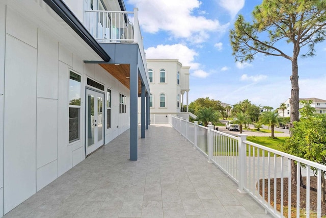 view of patio with a balcony and french doors