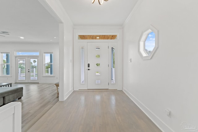 foyer with light wood-type flooring and ornamental molding