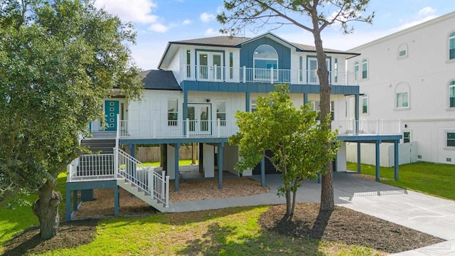 rear view of house with a carport, a balcony, and a lawn