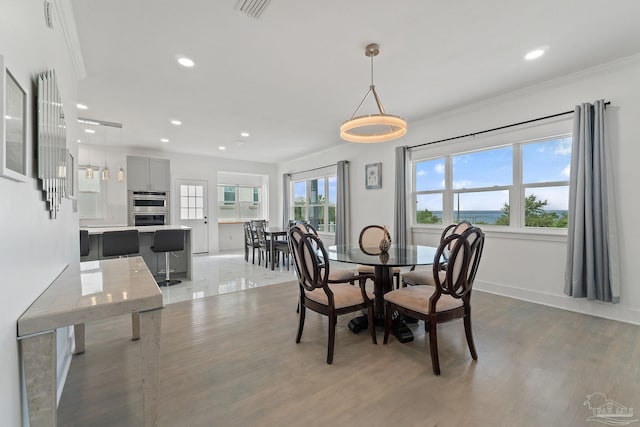 dining area with tile patterned floors and crown molding