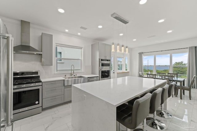 kitchen with tasteful backsplash, wall chimney range hood, sink, appliances with stainless steel finishes, and gray cabinetry