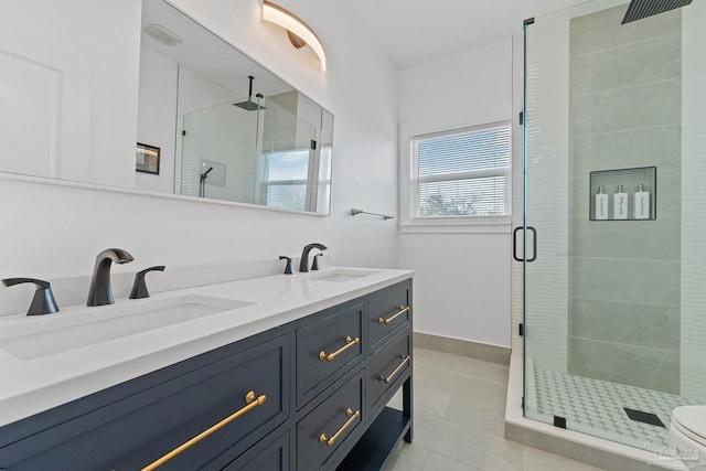 bathroom with a shower with shower door, tile patterned floors, toilet, and dual bowl vanity