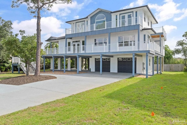 coastal home featuring a balcony, a garage, and a front yard