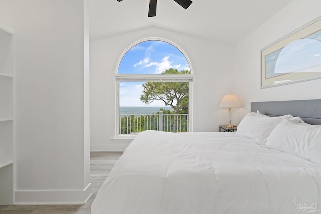 bedroom with light wood-type flooring, ceiling fan, and vaulted ceiling