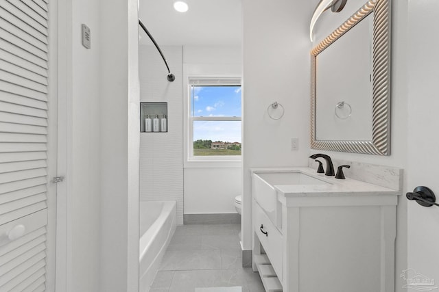 full bathroom with tile patterned flooring, toilet, tiled shower / bath combo, and vanity