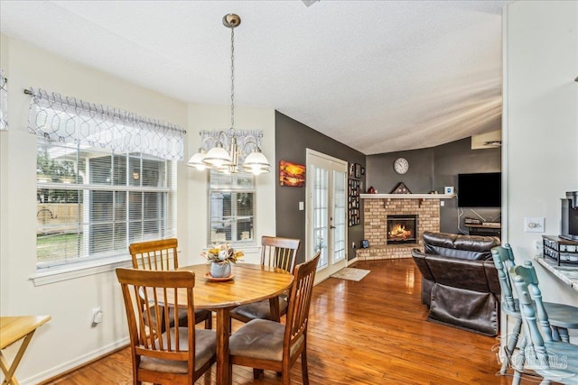 dining room featuring hardwood / wood-style flooring, lofted ceiling, and plenty of natural light