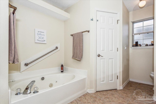 bathroom with tile patterned flooring, a bath, and a textured ceiling