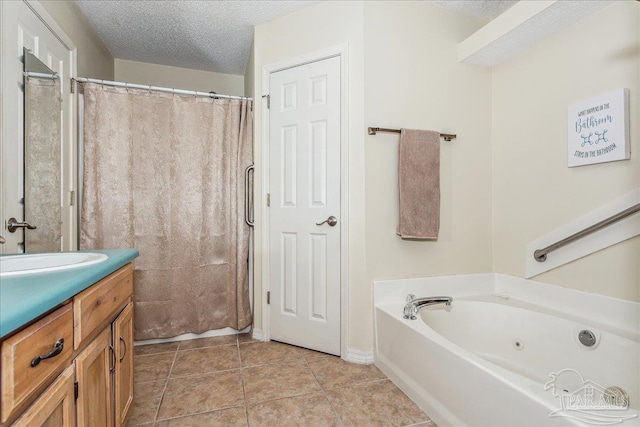 bathroom featuring tile patterned floors, vanity, a bathtub, and a textured ceiling