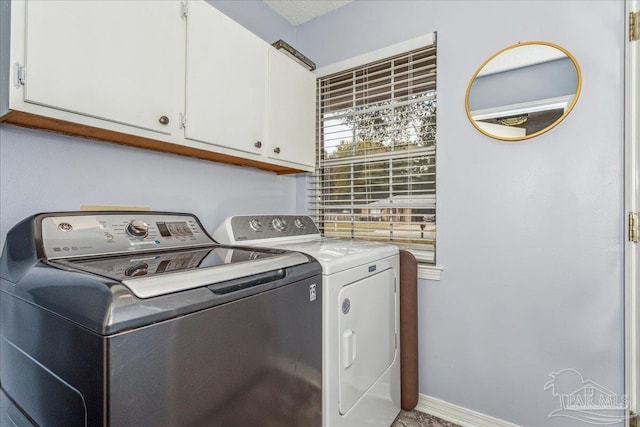 laundry room featuring cabinets and separate washer and dryer