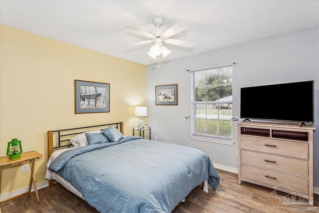 bedroom featuring hardwood / wood-style flooring, ceiling fan, and a textured ceiling