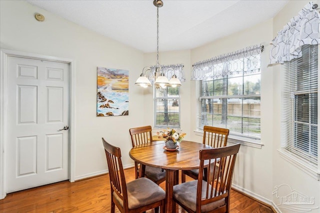 dining room with hardwood / wood-style flooring and a notable chandelier