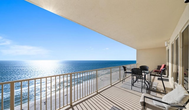 balcony featuring a water view and a view of the beach