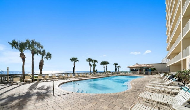 pool featuring a water view and a patio