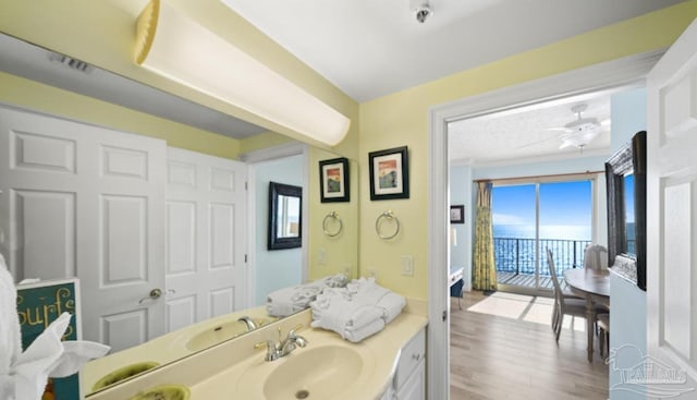 bathroom with ceiling fan, wood finished floors, and vanity