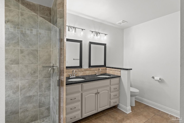 5473 Tucker Cir, Pace, FL 32571 - full bathroom with double vanity, toilet, a shower stall, tile patterned flooring, and baseboards