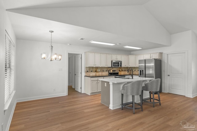 5473 Tucker Cir, Pace, FL 32571 - kitchen with appliances with stainless steel finishes, a chandelier, a breakfast bar, backsplash, and a sink
