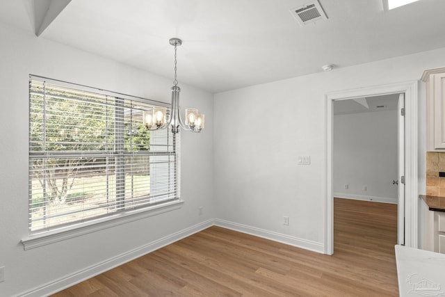 5473 Tucker Cir, Pace, FL 32571 - unfurnished dining area with plenty of natural light, a chandelier, light wood finished floors, and baseboards