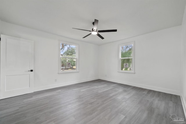 unfurnished room with a wealth of natural light, ceiling fan, and hardwood / wood-style flooring