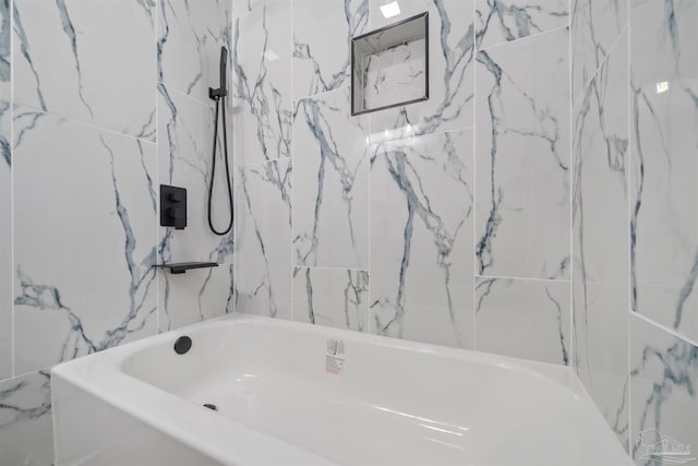 bathroom featuring tiled shower / bath combo and tile walls