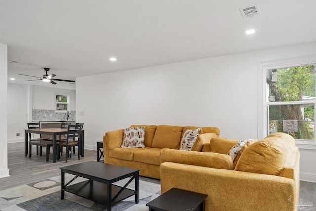 living room featuring ceiling fan and light hardwood / wood-style flooring