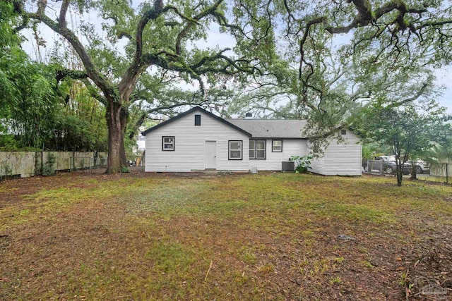 rear view of house with a lawn and central AC