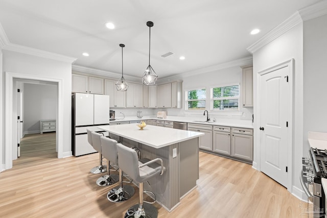 3041 Mountain Laurel Trl, Cantonment, FL 32533 - kitchen with visible vents, a breakfast bar, light wood-style floors, a sink, and appliances with stainless steel finishes