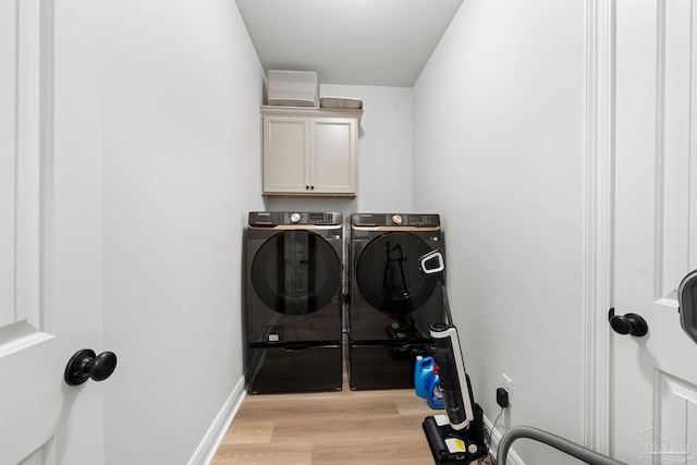 3041 Mountain Laurel Trl, Cantonment, FL 32533 - clothes washing area with light wood-style floors, washer and clothes dryer, and cabinet space