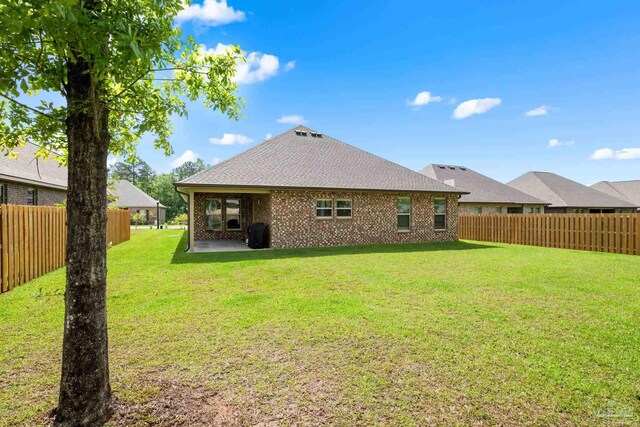 3041 Mountain Laurel Trl, Cantonment, FL 32533 - back of house with a lawn, a patio area, brick siding, a fenced backyard, and a shingled roof