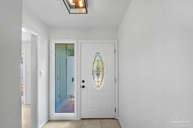 tiled entryway featuring a textured ceiling