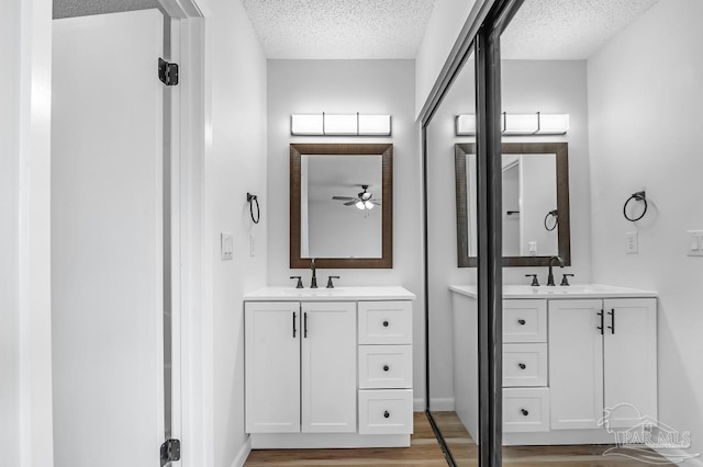 bathroom with hardwood / wood-style flooring, a textured ceiling, and vanity