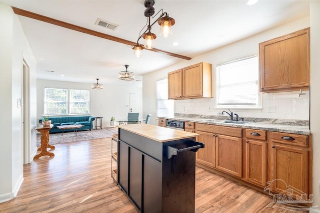 kitchen with a center island, light hardwood / wood-style floors, tasteful backsplash, and sink