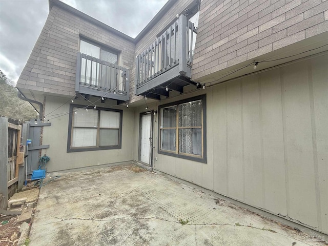 rear view of house featuring a patio area and a balcony