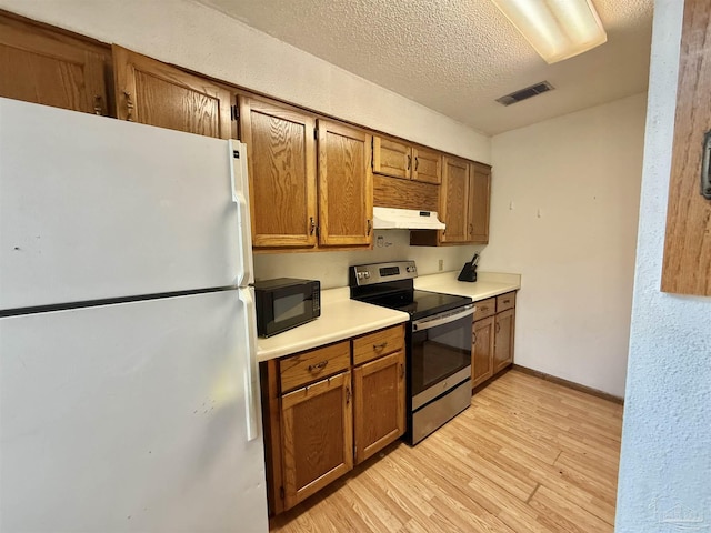 kitchen with stainless steel electric stove, a textured ceiling, white fridge, and light hardwood / wood-style flooring