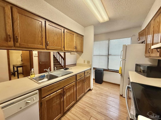 kitchen featuring sink, a textured ceiling, light wood-type flooring, dishwasher, and stainless steel electric stove