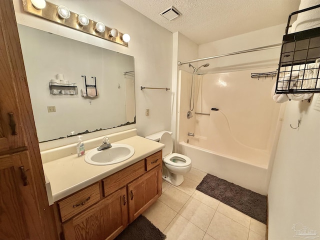 full bathroom with  shower combination, vanity, a textured ceiling, tile patterned floors, and toilet