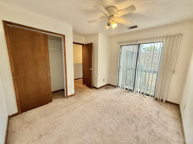 unfurnished bedroom featuring access to outside, ceiling fan, light carpet, a textured ceiling, and a closet