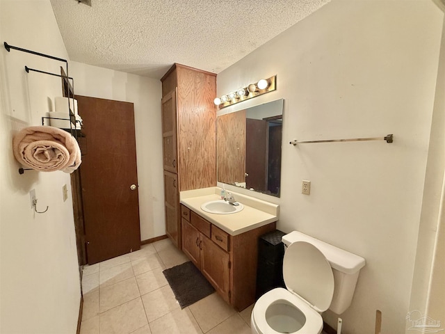 bathroom with tile patterned flooring, vanity, a textured ceiling, and toilet