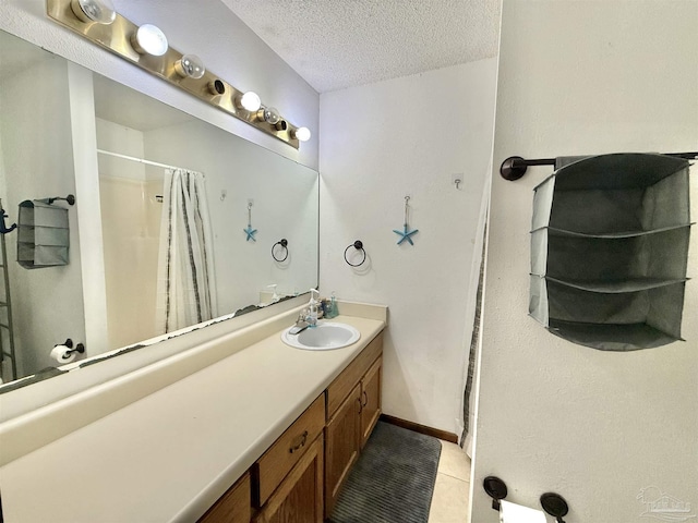 bathroom with walk in shower, vanity, tile patterned flooring, and a textured ceiling