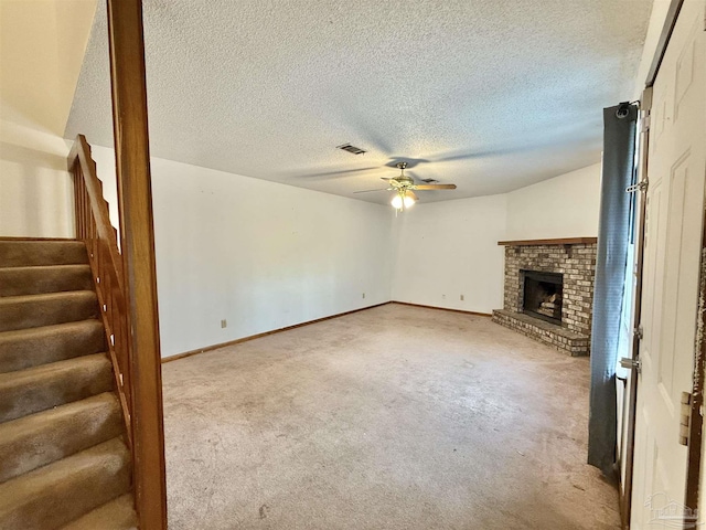 unfurnished living room featuring ceiling fan, carpet, a textured ceiling, and a fireplace